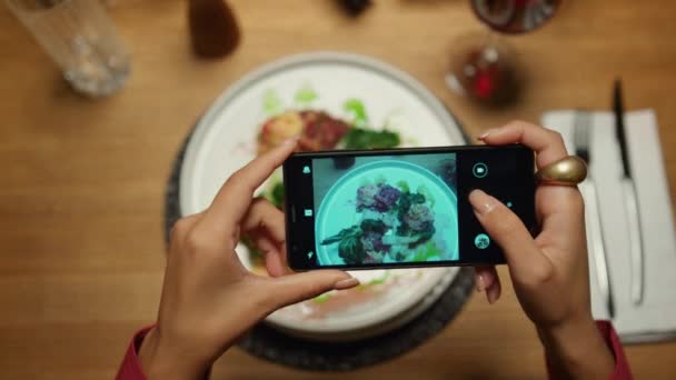 Kvinna tar bilder middag med hjälp av mobiltelefon i restaurang. Damen njuter av maten. — Stockvideo