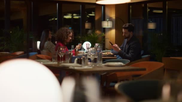 Couple occupé SMS téléphone appareil mobile le soir restaurant dîner date. — Video