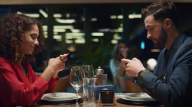 Lüks bir restoranda çok ırklı bir çift cep telefonuna mesaj atıyor. Akşam yemeği konsepti