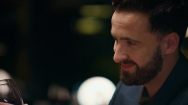 Lüks restoranda şarap kadehi içen yakışıklı bir adam. Randevu yemeği konsepti.