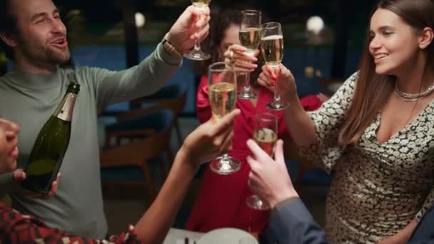 Багатоетнічна група п'є шампанське в ресторані. Друзі святкують вечірку . — стокове відео