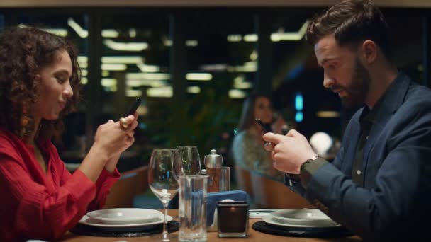 Digital pareja surfeando teléfono en la cena del restaurante fecha. Concepto de redes sociales. — Vídeos de Stock