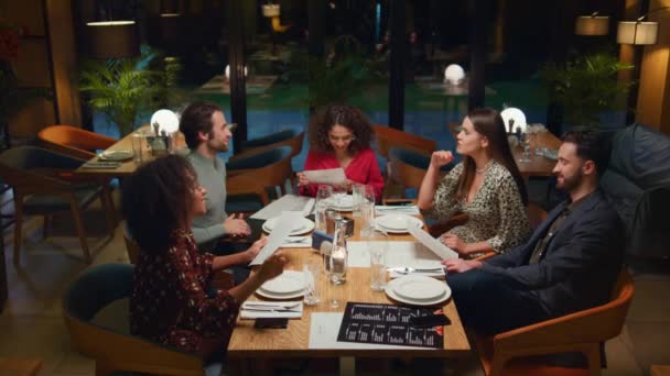 Blandade race vänner pratar i restaurang. Människor grupp välja meny i café. — Stockvideo
