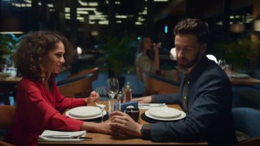 Flört eden çift restoranda el ele tutuşuyor. Akşam yemeğinde kız arkadaşını öpen adam..