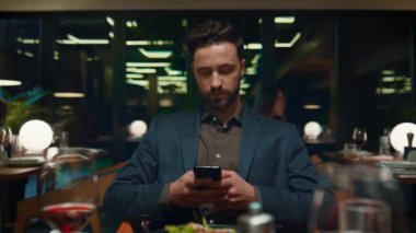 Restorana odaklanmış iş adamı. Saygıdeğer adam cep telefonuna mesaj atıyor.