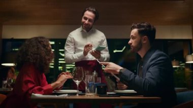 Restoranda çifte servis yapan gülümseyen garson. Kafe barında karışık ırk aşıkları.