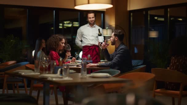 Servitören serverar romantiska par på restaurang. Sommelier som håller vinflaska. — Stockvideo