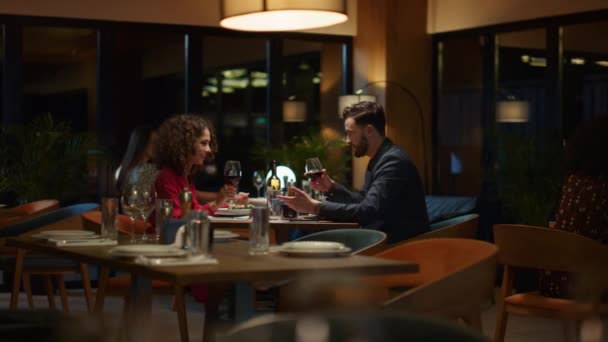 Gelukkig stel dat wijnglas drinkt in een chique restauranttafel. Romantisch concept. — Stockvideo
