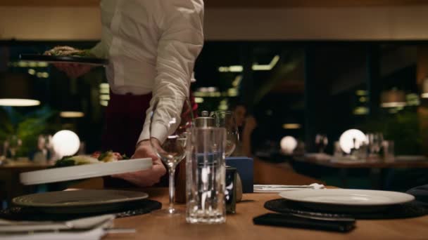 Kelner kładący talerze na stole. Romantyczna para cieszyć się porcją w barze. — Wideo stockowe