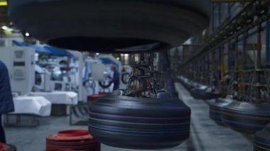 Depodaki lastik fabrikası işçileri modern makinelerle çalışıyorlar.