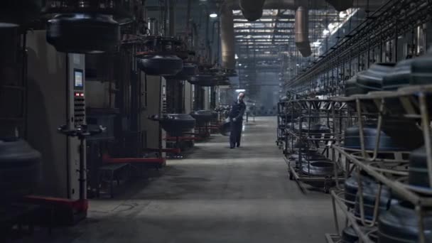 Lagerarbetare vid däckverket som transporterar ny gummiprodukt i verkstaden — Stockvideo