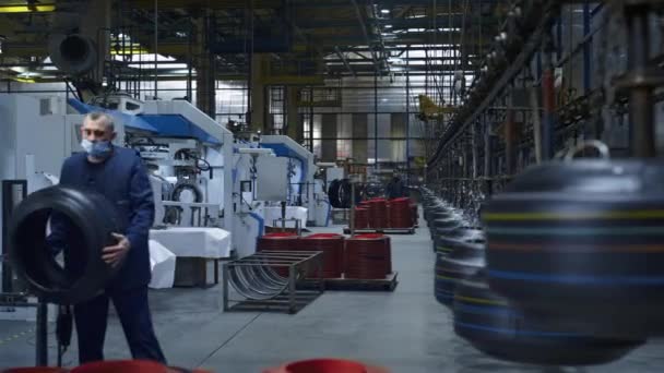 Tyre production storage employees working in factory carrying rubber product — Stock Video