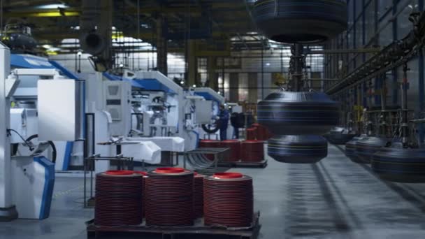 Máquinas tecnológicas de almacenamiento de fábrica de neumáticos modernos con trabajador de fondo — Vídeos de Stock