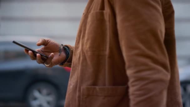 Manos masculinas usando teléfono inteligente caminando primer plano de la calle de la ciudad. Usuario seguro de la aplicación. — Vídeos de Stock