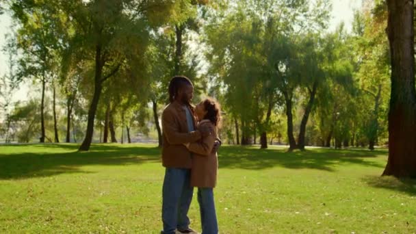 父亲在阳光灿烂的秋天公园拥抱女儿.感情上的联系. — 图库视频影像