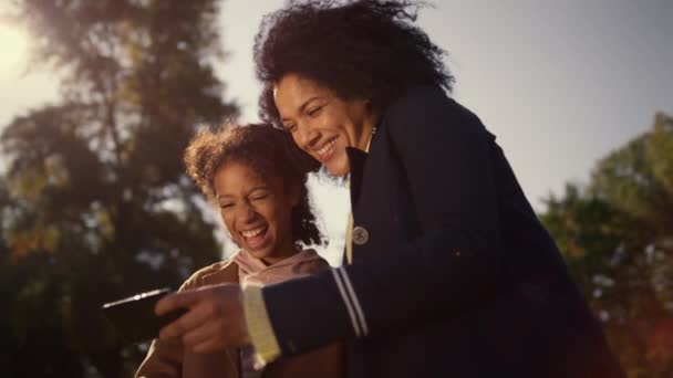 Lachende moeder die selfie maakt met een vrolijk kind. Vrolijke momenten samen park. — Stockvideo