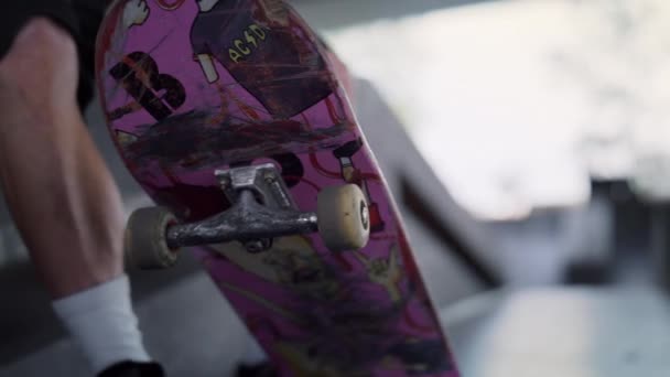 无法辨认的男子与粉色滑板在城市滑板公园休息. — 图库视频影像