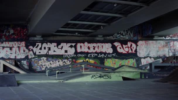 Skate park s uměleckou graffiti stěnou. Městský tréninkový prostor se železnicí a rampou. — Stock video