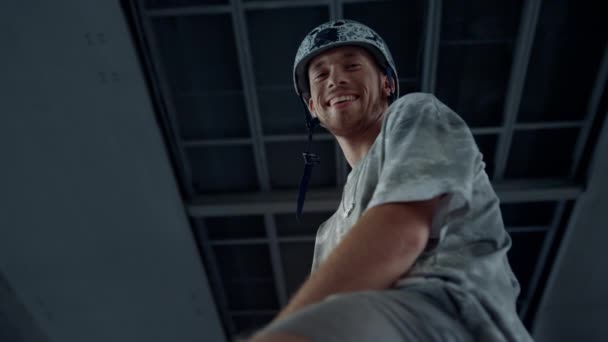 En glad mand, der kigger på kameraet i en skatepark. Smilende ung rulleskøjter. – Stock-video