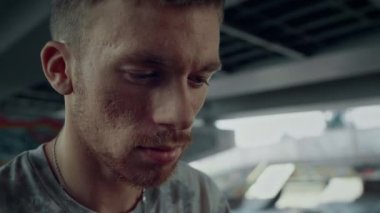 Kaykay parkında cep telefonundan haber okuyan çekici bir adam. Portre odaklı genç