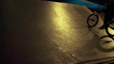 Kaykay parkında bisiklet süren sportif bir adam. Erkekler ekstrem sporlardan hoşlanır.