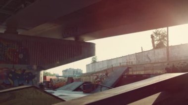 Şehir kaykay parkında paten kayarak atlama numarası yapan genç bir çocuk..