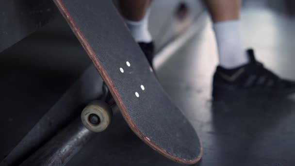 Ung hipster vilar med skateboard på skateparken. Närbild skateboard. — Stockvideo