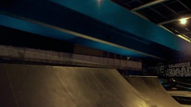 Sporcu adam gece şehir kaykay parkında BMX bisikleti üzerinde tehlikeli numaralar yapıyor..