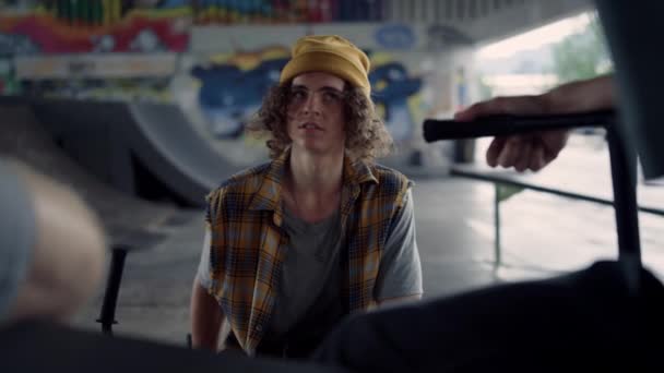 Young people talking together at skate park graffiti. Teens resting outdoors. — Stock Video