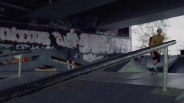 Skateboarder cercando trucco su rotaia fuori. Pattinatore adolescente che salta sul pattino. — Video Stock