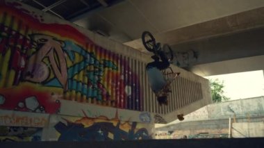 Kaykay parkında BMX bisikleti üzerinde enerjik çocuk eğitim yetenekleri. Motorcu dışarıda takla atıyor..