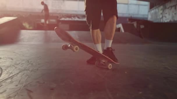 Aktivní muž cvičí skateboard v skate parku s graffiti na zdi. — Stock video