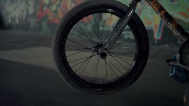 ВМХ велосипедное колесо крутится в скейтпарке с граффити-стеной. Парковка велосипедов. — стоковое видео