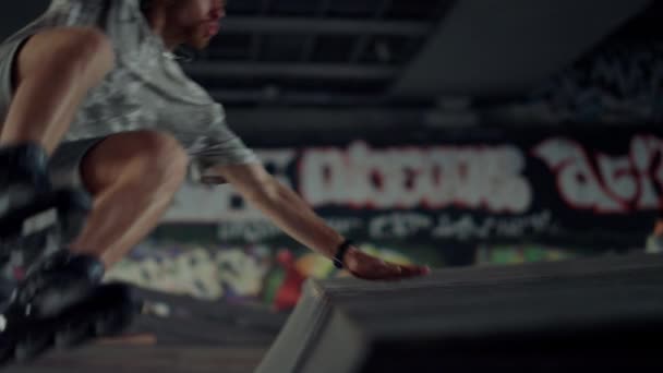 Hombre deportivo realizando trucos de salto en patines en skate park urbano. — Vídeo de stock