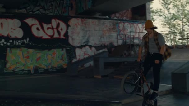 Niño enérgico realizando trucos en bicicleta bmx en el parque público de skate. — Vídeos de Stock