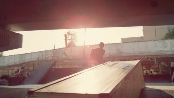 Mladý bruslař provedení trik na skate board brusle. Hipster skateboarding — Stock video