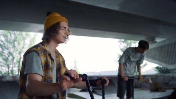 Happy hipster gesturing hand at skatepark. Handsome man smiling on camera. — Stock Video