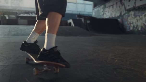 Habilidades de entrenamiento de hombre deportivo en skate board al atardecer en el parque de skate urbano. — Vídeo de stock