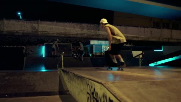 Amis extrêmes effectuant cascade de saut sur rail au skate park de nuit. Concept sportif — Video