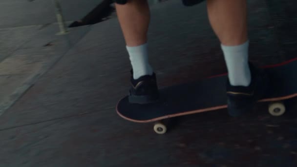 Adolescente attivo in scarpe da ginnastica cavalcando su skate board nel moderno parco skate urbano. — Video Stock