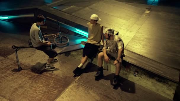 Amigos relaxados se comunicando juntos no parque de skate com parede de grafite. — Vídeo de Stock