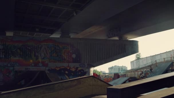 Skate park com graffiti artístico na parede. Parque de skate vazio com trilho e rampa. — Vídeo de Stock