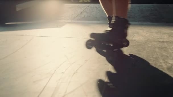 Молодой роллер практикует трюк в скейт-парке. Мужские ноги на роликах. — стоковое видео