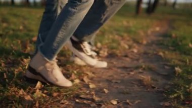 Anne ve babası, Autumn Park sahasında birlikte yürüyorlar. Yakın çekim. Açık hava eğlence zamanı.