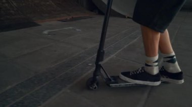 Aktif scooter sürücüsü kaykay parkındaki serbest stil oturumunda numaralar yapıyor.