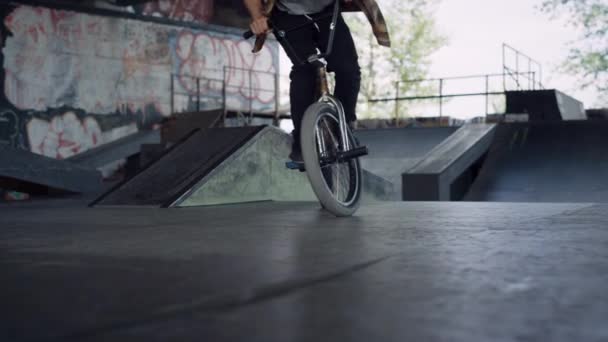 Hombre deportivo montando bicicleta bmx en skatepark. Bmx rider realizar truco al aire libre. — Vídeos de Stock