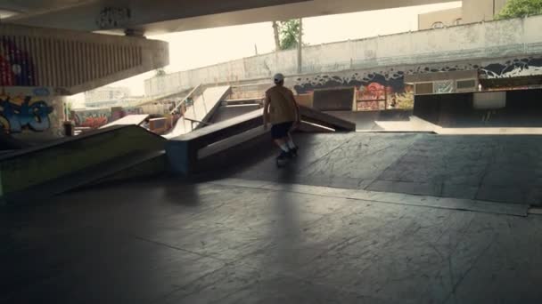 Patinador enérgico realizando trucos durante la sesión de freestyle en skate park. — Vídeos de Stock