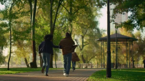 後ろの景色を一緒に走る家族休憩秋の公園。ハッピーレジャータイム. — ストック動画