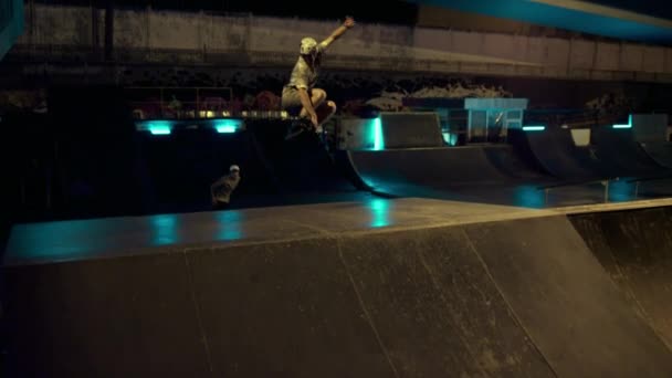 Sportovní lidé dělají cvičení společně na kolečkových bruslích a skateboard v rampě. — Stock video