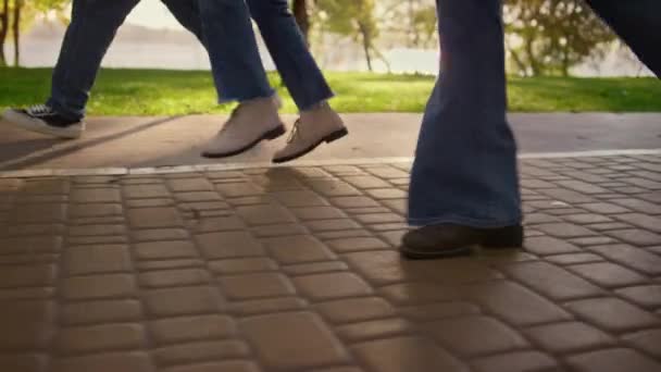 Πόδια που περπατούν σε στενό δρόμο. Οικογένεια απολαμβάνοντας προειδοποιούν ηλιόλουστη βραδιά στο πάρκο. — Αρχείο Βίντεο